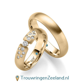 Trouwringen in 14/18 karaat ros&eacute;goud mat met in de damesring 1 grote diamant geklemd en aan weerszijden 6 kleinere diamanten